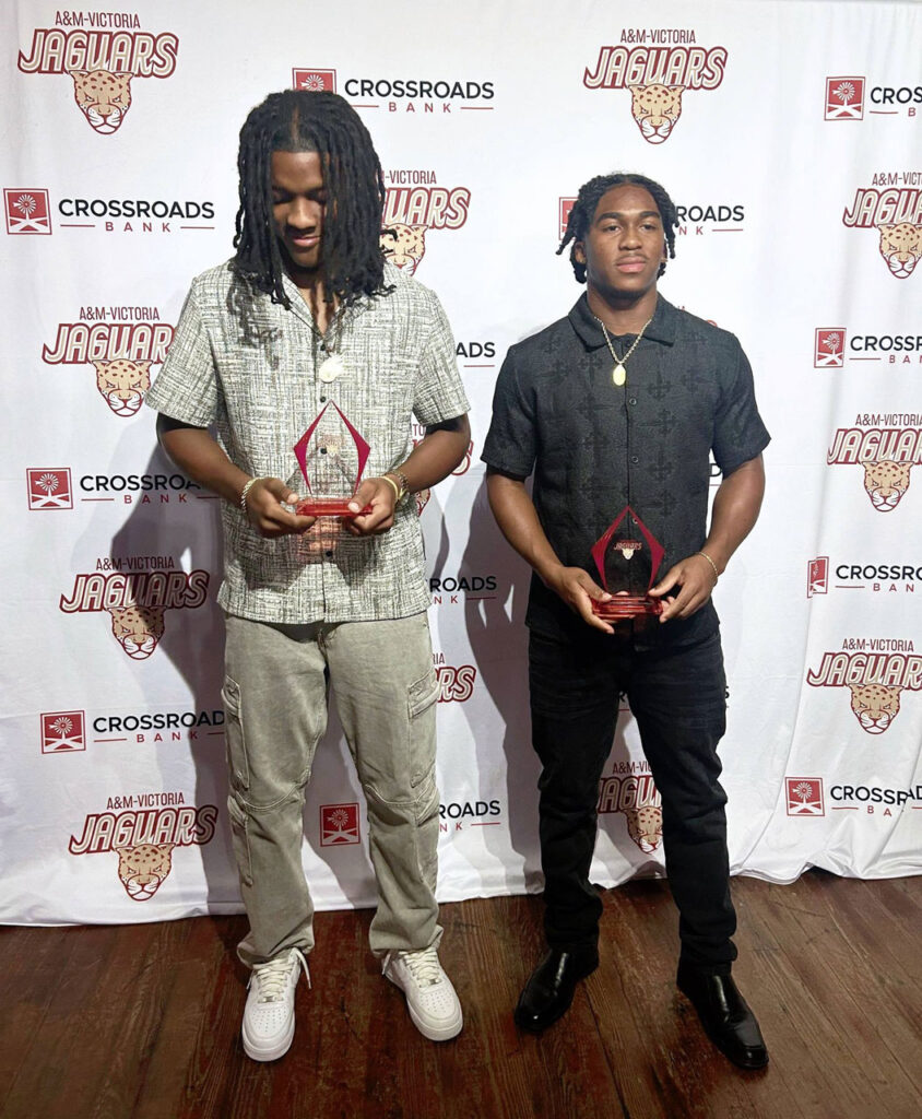 Jervan and Mosiah posing for a photo with their awards in hand