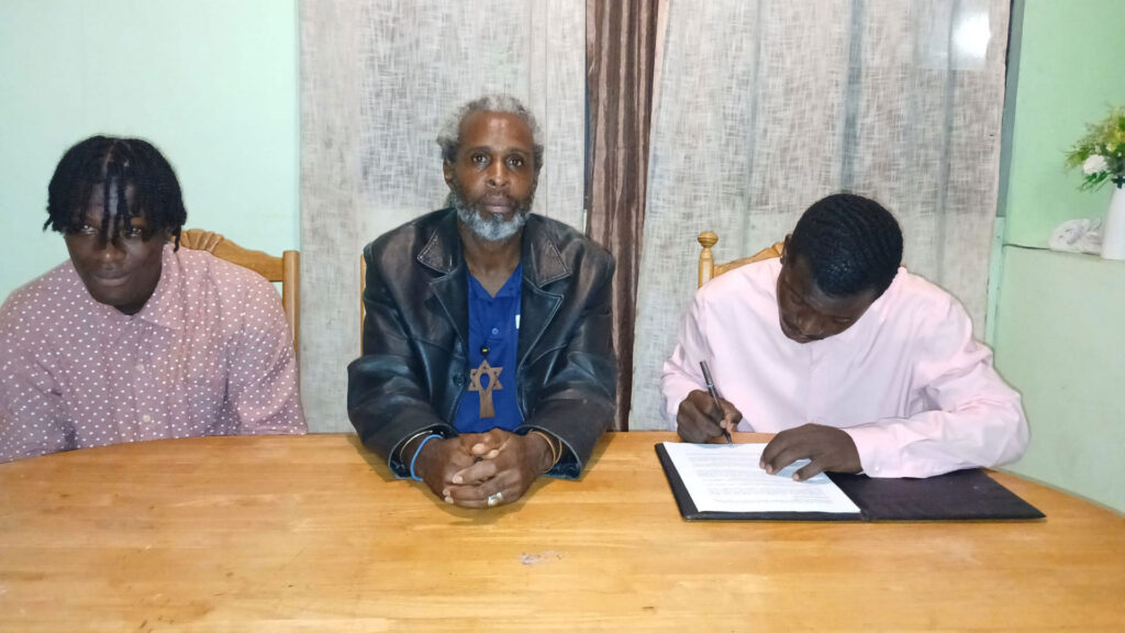 Middleham United FC new player Clayson Pascal signing the transfer documents