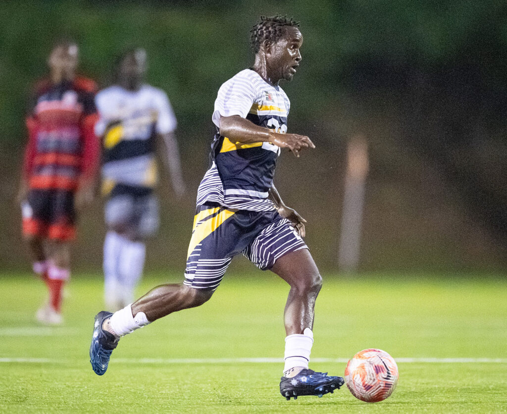 Middleham United FC player Curtly Augustine driving forward with the ball at his feet