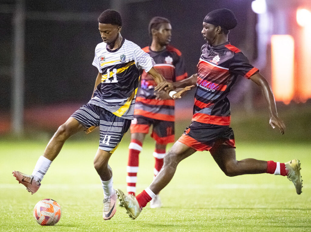 Middleham United FC player Ajani Richards under pressure from the Pointe Michel FC defense