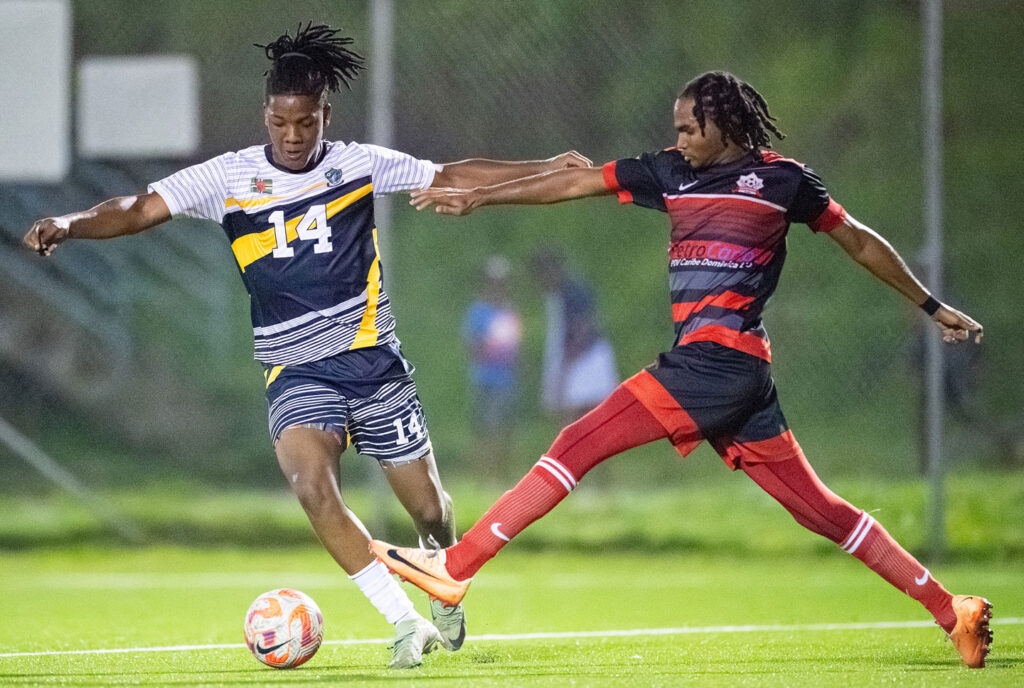 Middleham United FC player Jervon Matthew avoiding a Pointe Michel player