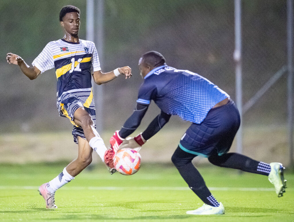Middleham United FC player Ajani Richards attempting to win a ball against the East Central FC goalie